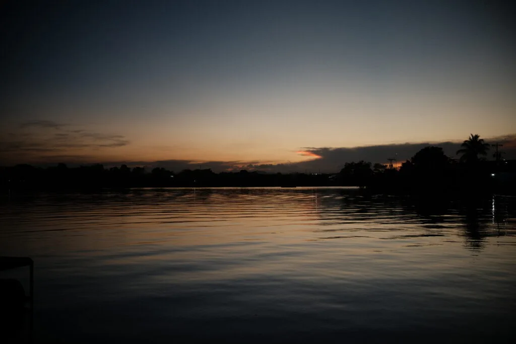 Sunset over the lake in Flores, Guatemala, with golden hues reflected on the water