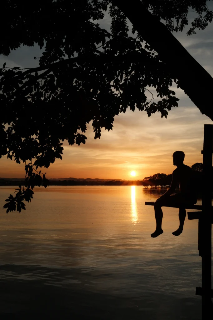 Man staring at sunset over water