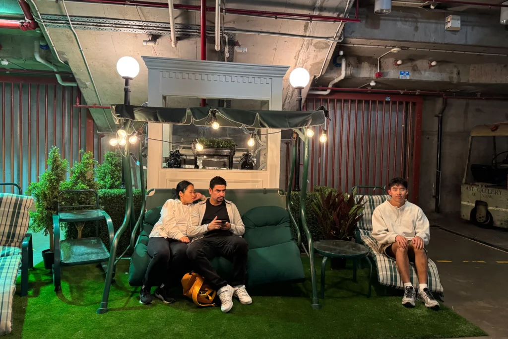 Couple sitting on green chair looking confused, me on the right sitting on a lone chair staring at the camera