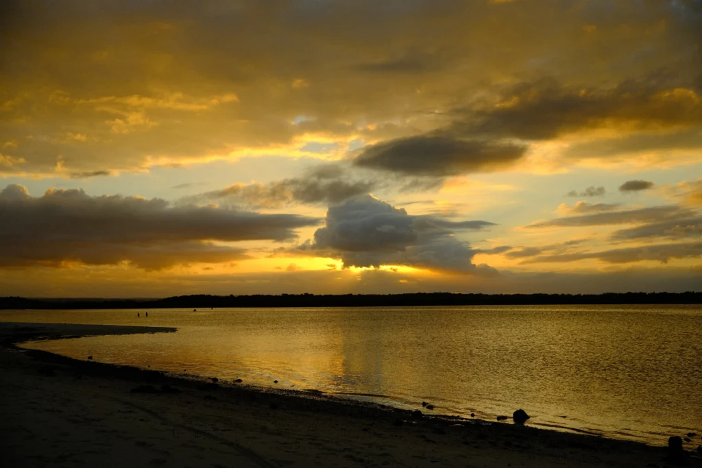 A golden sunset over calm waters.
