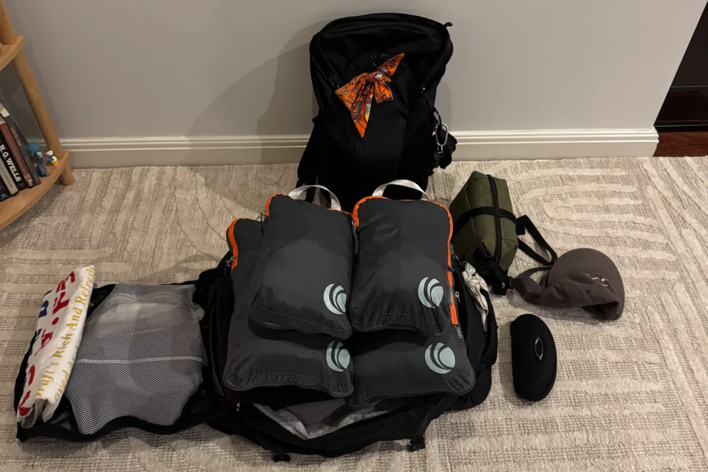 An open 55L osprey bag with four packing cubes inside