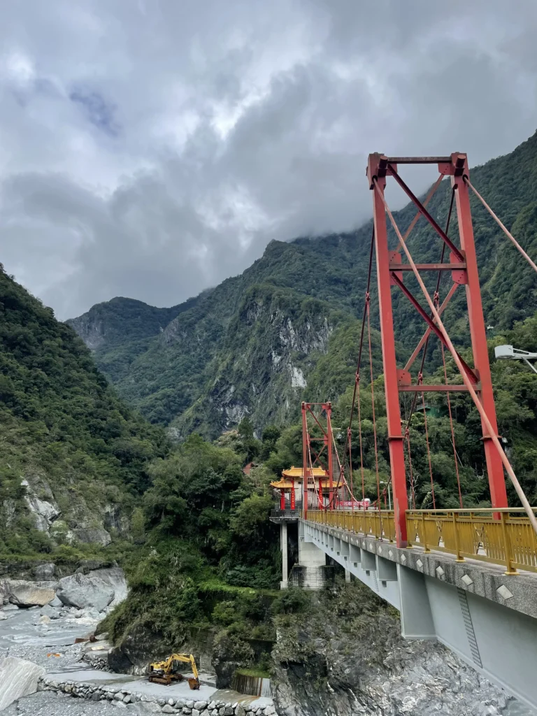 Red bridge stretching into mountains