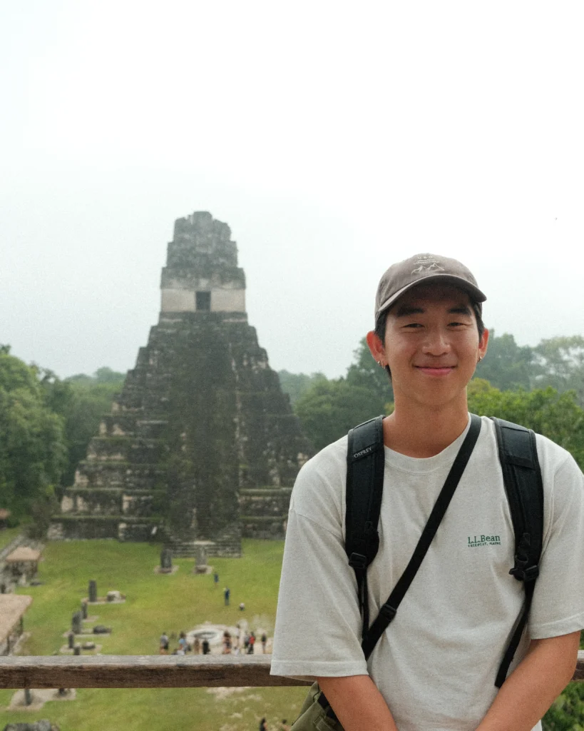 Me smiling, standing in front of a Maya pyramid in Tikal