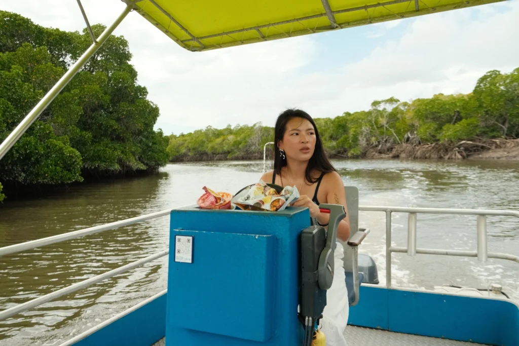 Girl looking away driving a boat on croc infested waters