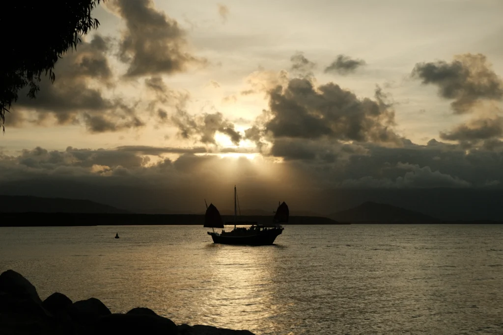 Chinese junk boat on calm waters at sunset in Port Douglas